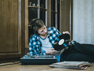 Fototapeta na wymiar portrait of young man at home listening to the vinyl records, relaxing and dreaning
