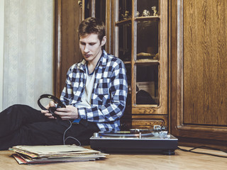 Fototapeta na wymiar portrait of young man listens to music vinyl record on the turntable