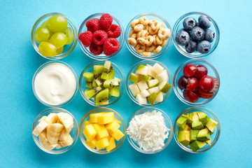 Food ingredients in glass bowls on blue, from above