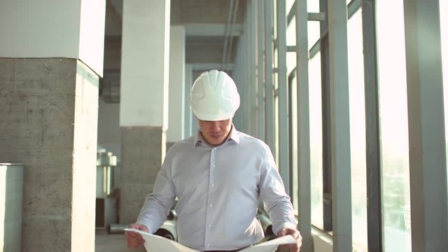 on a construction site, a worker or an engineer or architect controls the design and construction of the building with high energy savings. Concept: construction, worker, engineering, design. 4 k