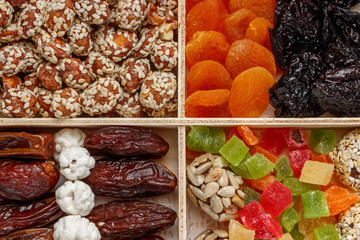 In the wooden package is dried apricots, peanuts, sesame, dried fruits, kumquat, plum