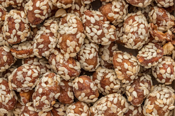 Food background made of peanuts covered with glaze and sprinkled with sesame seeds