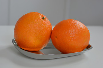 Saftige Orangen auf einer silbernen Schale
