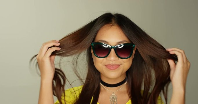 4K Close up Beautiful Asian girl wearing sunglasses with lighting reflected in the lenses. Slow motion.