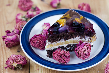 fruit cake with chocolate meringue white cream in a plate
