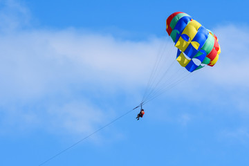 Tourists enjoying parasailing in a blue sky of Roatan, Honduras.