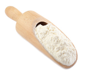 Wooden scoop with wheat flour on white background