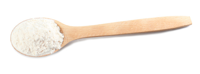 Wooden spoon with wheat flour on white background