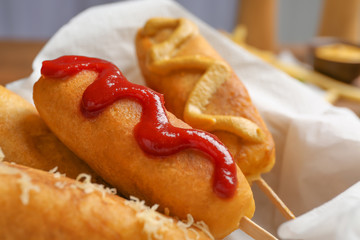 Tasty corn dogs with sauces, closeup