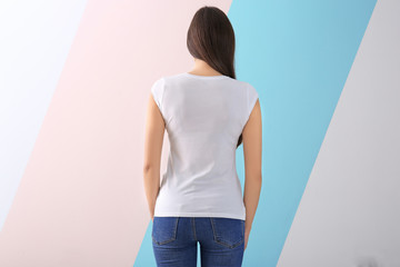 Fototapeta na wymiar Young woman in stylish t-shirt on color background. Mockup for design