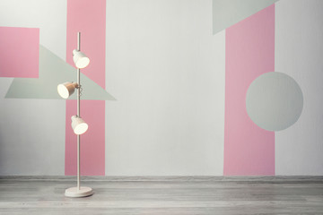 Stylish floor lamp near color wall