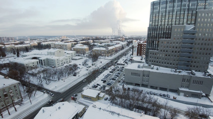 Obraz premium Apartment buildings or blocks of flats covered by snow. Clip. Urban winter landscape with street perspective aerial top view. Clip. The skyscrapers in the city. City life. Amazing city landscape.
