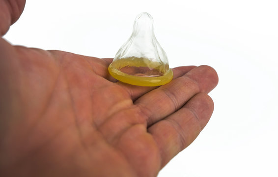 Close-up of a condom in his hand. Contraceptive protection against pregnancy, AIDS.