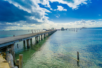 Outdoor view of a wooden dock into blue tropical sea in Isla Mujeres, Yucatan Mexico