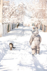 child in the forest in the snow with cat