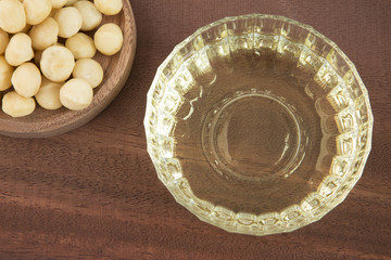 Organic macadamia nuts and oil on wooden table