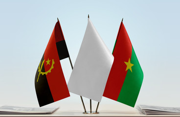 Flags of Angola and Burkina Faso with a white flag in the middle