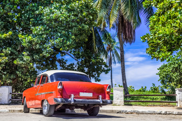 Roter amerikanischer Oldtimer mit weissem Dach parkt unter blauem Himmel in Varadero Kuba - HDR - Serie Cuba Reportage