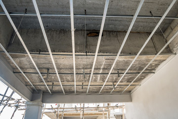 Install metal frame for plaster board ceiling at house under construction
