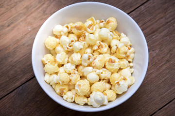 A bowl of popcorn on a wooden table