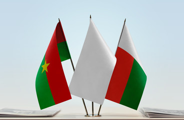 Flags of Burkina Faso and Madagascar with a white flag in the middle