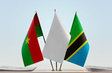 Flags of Burkina Faso and Tanzania with a white flag in the middle