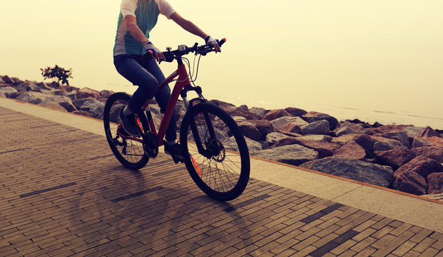 cyclist riding bike on the sunrise coast path