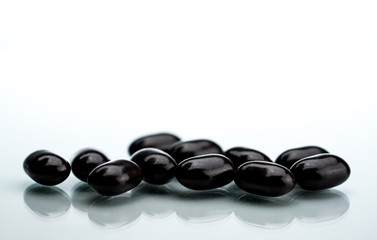 Black tablet pills on a white background. Vitamins and minerals tablets for pregnant women. Ferrous fumarate anemia treatment tablets pills.