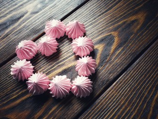 airy pink and white meringue on wooden background     