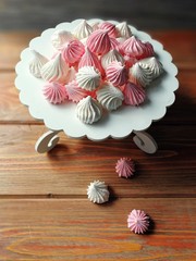 airy pink and white meringue on wooden background     