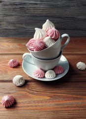 airy pink and white meringue on wooden background     