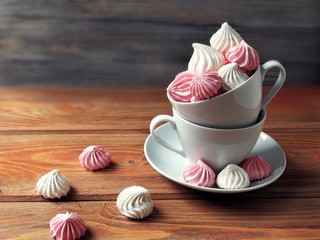 airy pink and white meringue on wooden background     