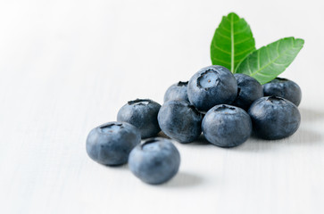 fresh blueberry fruits with leaf on white wood