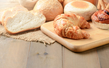 Homemade croissant and bread on old wood