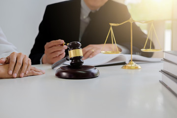 Judge gavel with Justice  lawyers having team meeting at law firm in background. Concepts of law.