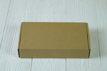 Empty Package brown cardboard box or tray on bright wooden table with copy space.