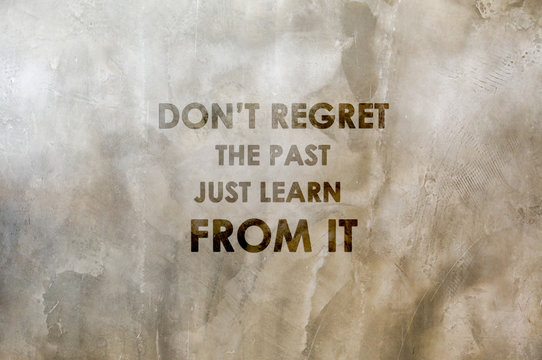 Inspirational positive quote “Don't regret the past, just learn from it.” with cement wall background.