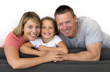 Fototapeta premium young beautiful and happy Caucasian couple with mother and father posing cheerful together with adorable 7 years old blond little girl