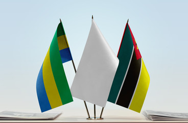 Flags of Gabon and Mozambique with a white flag in the middle
