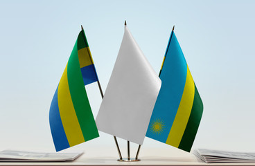 Flags of Gabon and Rwanda with a white flag in the middle