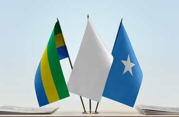 Flags of Gabon and Somalia with a white flag in the middle