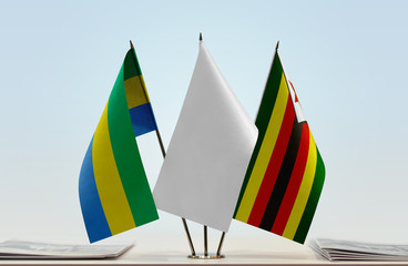 Flags of Gabon and Zimbabwe with a white flag in the middle