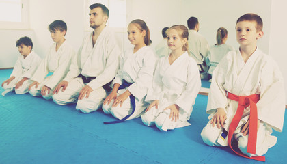 Fototapeta na wymiar Happy children enjoying their trainings with coach at karate class