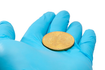 hand in blue glove holding bitcoin on white background