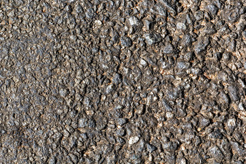 Surface of the old asphalt with the transition from small fractions to large ones. Background texture. Road surface