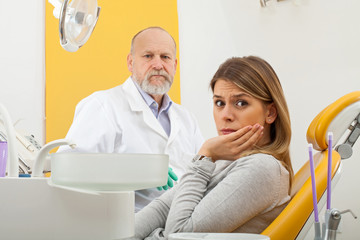 Fototapeta premium Female patient with toothache at the dentist office