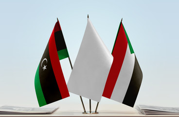 Flags of Libya and Sudan with a white flag in the middle