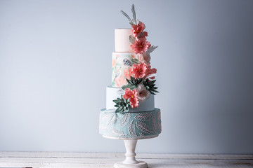 Gâteau de mariage à quatre étages décoré de fleurs rouges printanières et de motifs faits à la main. Concept de délicieux desserts
