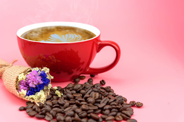 red coffee mug with flower and coffee beans