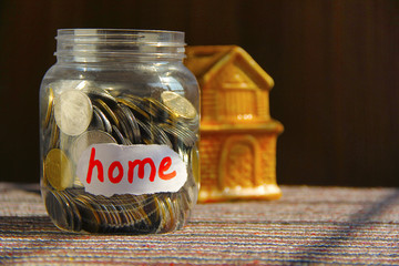 Coins in money jar with home label - obrazy, fototapety, plakaty